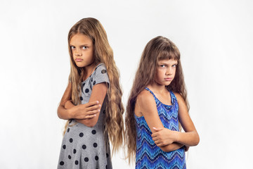 Two offended girls stand with their backs to each other