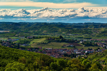 Fototapeta premium City of Alba heart of the Langhe in Piedmont Italy view from above surrounded by hills full of vineyards and woods in the sky suggestive clouds