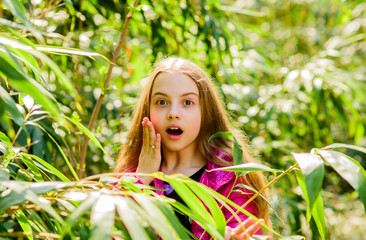 Fototapeta premium summer nature. Natural beauty. Childhood happiness. Spring holiday. Green environment. little girl spend free time in park. happy child in park. surprised kid in jungle. traveling concept