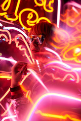 Portrait of woman with silver jacket and sunglasses in neon lights