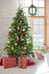 Fototapeta na wymiar Christmas tree and gift boxes near the window