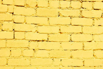 Painted brick wall in yellow or living coral color background texture, empty space for your design