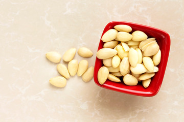 fresh not peeled almond in red bowl