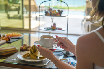 a woman drinking coffee and snacks
