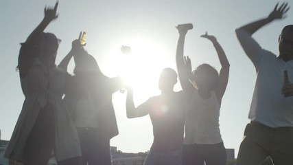 Happy young people having fun together. Smiling friends dancing with raised hands. Leisure concept