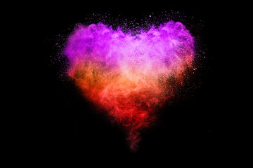Freeze motion of purple color powder exploding on black background.