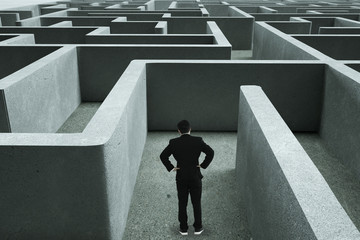 Businessman going straight ahead on a wide road between mazes