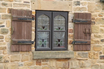 Fototapeta na wymiar Ancient Wooden Shutters for a Leaded Window.