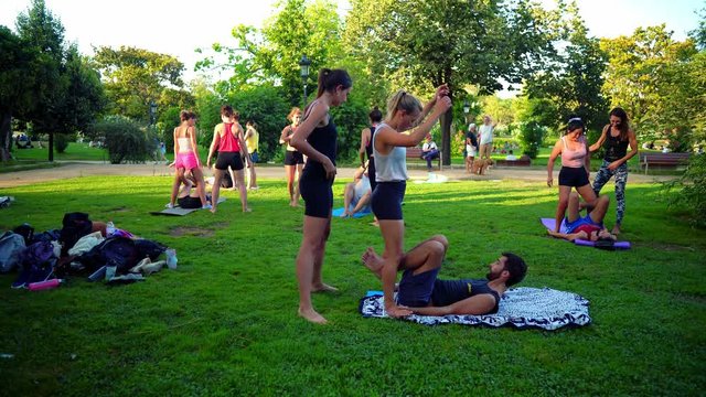 A group lesson on acroyoga master class which takes place on the lawn in the park. 4k shot