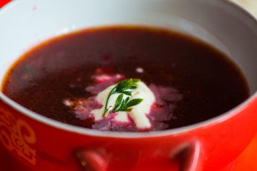  Red soup with vegetables with slices of bread on a pink bright background
