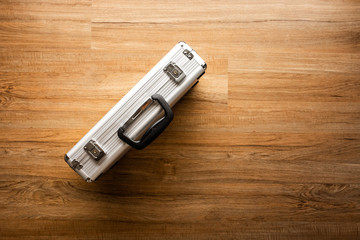 Above of metal briefcase(Box)on wooden floor background.Tool and security concepts