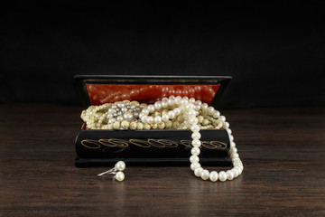 Pearls in old jewelry open chest, vintage treasure box and pearl necklaces. Design concept. Picture...