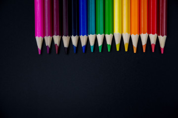 Color pencils on a charcoal blackboard background. Back to school. Empty space for text input