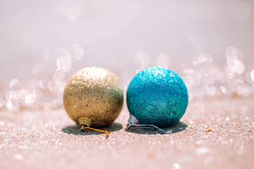 Two New Year's balls on a sandy beach.
