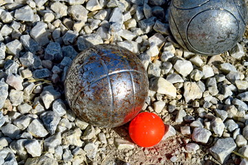 Gros plan sur boules de p&eacute;tanque et cochonnet sur terrain de gravier.