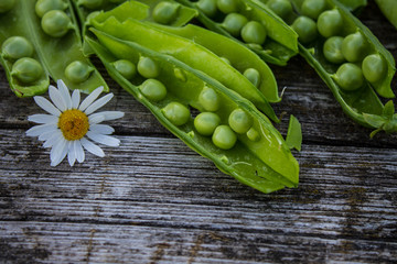Green pea pods on an old wooden table