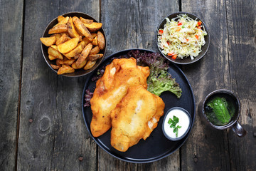 Fried fish in batter with chips and salad.