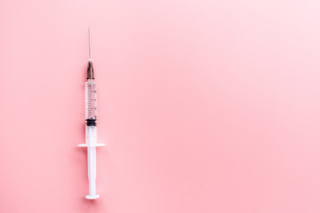 Medical syringe on pink background, health and vaccination concept. Flat lay, mockup, overhead, top...