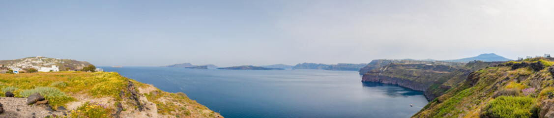 Wide view from the bay near the city of Akrotiri, to the inner coastline of the volcanic Thera archipelago and the Nea Kameni island in the center.