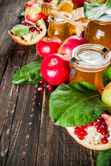 Jewish Autumn Rosh Hashana celebration. Traditional products for the celebration of Rosh Hashanah - apples with leaves, pomegranate, honey, honeycombs, wooden background