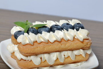 Cakes made from Italian savoyardi cookies and cream. Decorated with blueberries and mint leaves.