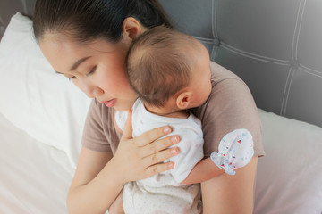 Beautiful mother holding her lovely baby . Infant resting on the shoulder to burp,