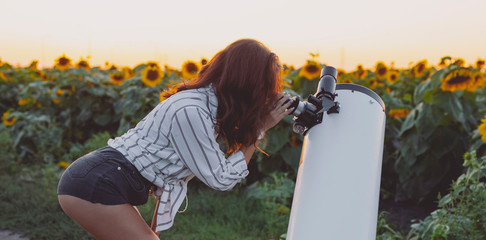 Sexy woman looking through telescope
