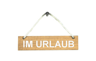 Altes isoliertes Holzschild zeigt: Im Urlaub