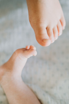 girl's feet and baby's feet touching