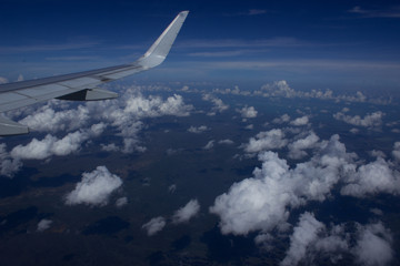 wing of an airplane flying above the clouds