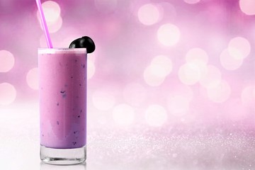 Glass of delicious berry cocktail on perple background