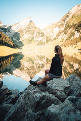 Naklejka premium woman sitting at mountain lake