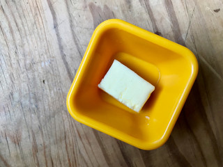 Butter Piece in Yellow Plastic Cup Ready to Use.