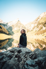 Fototapeta premium smiling woman sitting at mountain lake
