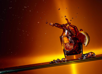 Plakat Slice of lemon falling into a glass of Cola.