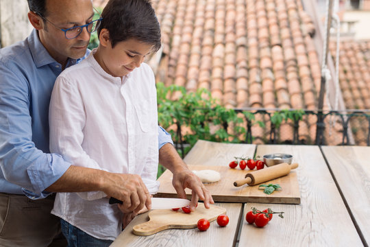 Father and son preparing pizza together