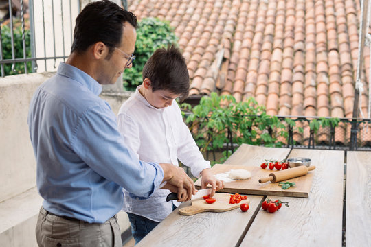 Father and son preparing pizza together
