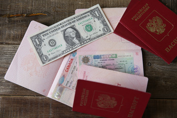 Russian passport with a Canadian and Schengen visa and money - one dollar. Visa stamp travel passport. Vacation and travel concept.