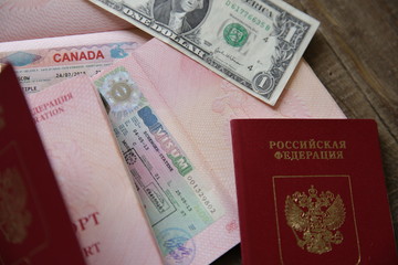 Russian passport with a Canadian and Schengen visa and money - one dollar. Visa stamp travel passport. Vacation and travel concept.
