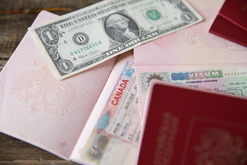 Russian passport with a Canadian and Schengen visa and money - one dollar. Visa stamp travel passport. Vacation and travel concept.