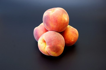 Fototapeta na wymiar Some frech ripe peaches on dark gray background cluse up view