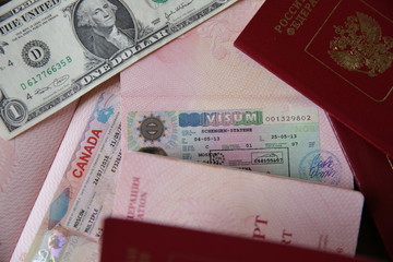 Russian passport with a Canadian and Schengen visa and money - one dollar. Visa stamp travel passport. Vacation and travel concept.