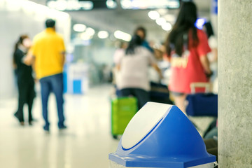 Blue cover transparent trashcan for increasing safety measures placed on the floor in the airport.