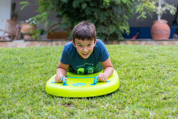Niño bajando por el césped con table de bodyboard © Cvilaclara