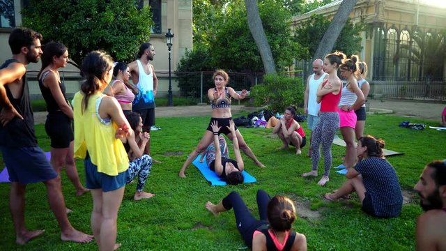 A group lesson on acroyoga master class which takes place on the lawn in the park. 4k shot