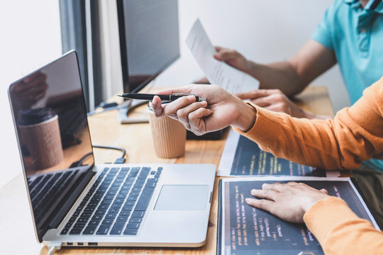 Two professional programmer cooperating and working on web site project in a software developing on desktop computer at company, codes and typing data code, Programming with HTML, PHP and javascript