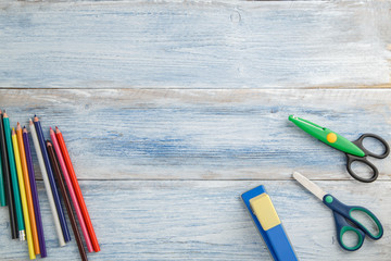 school children's concept. colored pencils,stapler and scissors on a blue and white scuffed vintage...