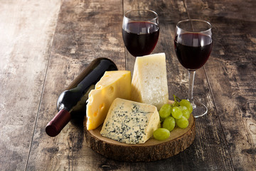 Assortment of cheeses and wine on wooden table