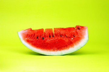 Slice of watermelon on yellow background.