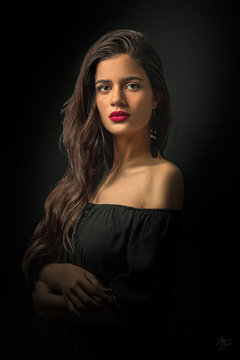 Portrait of a young romantic woman with black in a vintage sitting over black background